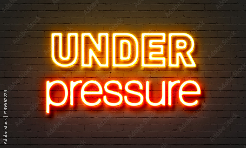 Obraz premium Under pressure neon sign on brick wall background.