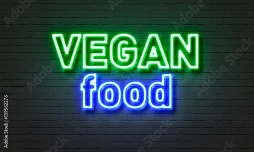 Vegan food neon sign on brick wall background.