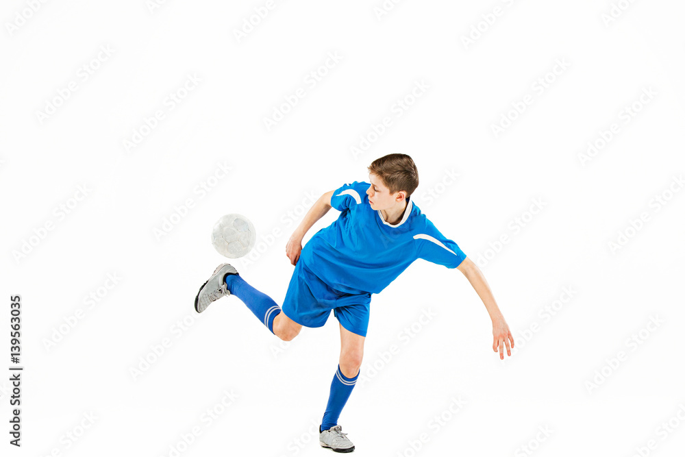 Young boy with soccer ball doing flying kick