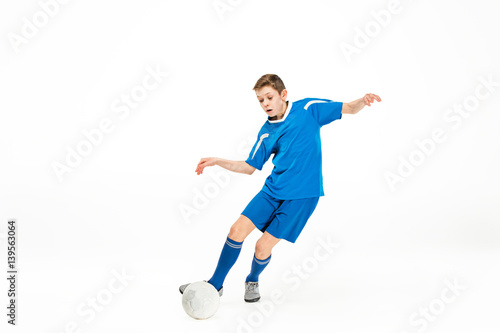 Young boy with soccer ball doing flying kick © master1305
