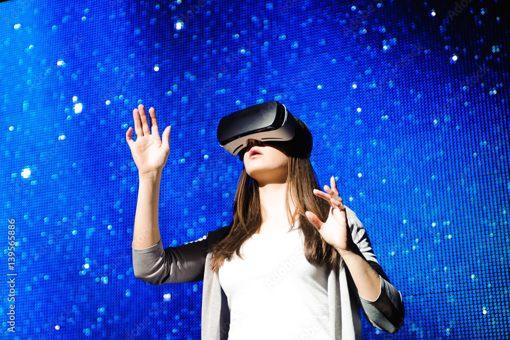 a beautiful girl wearing a virtual reality device, standing on the background of the sky a beautiful girl wearing a virtual reality device, standing on the background of the sky