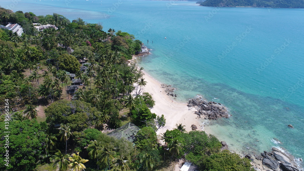 Fototapeta premium Aerial view of sea coastline and island with palm trees in Phuket, Thailand