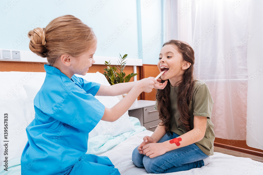 side view of girl nurse checking patient's throat in hospital