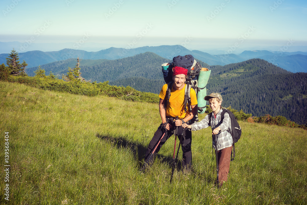 Happy father and son with backpacks