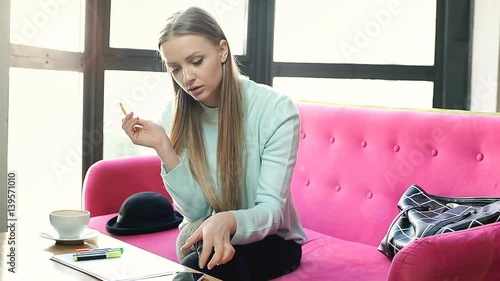 Girl learns notes by heart and checks some information in the internet
 photo