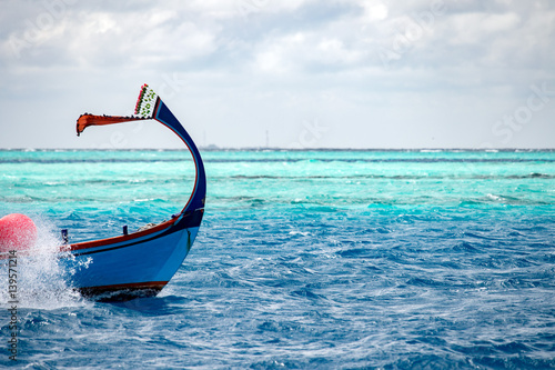 maldivian dhoni boat in blue ocean photo