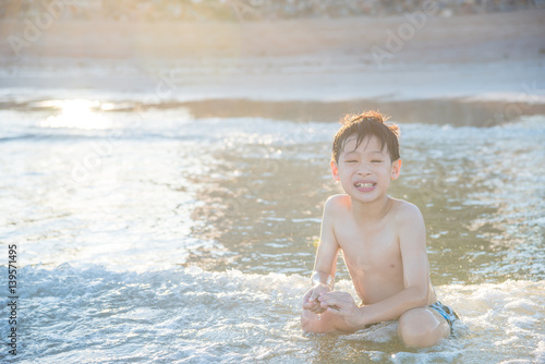 Young asian boy playing on the beach