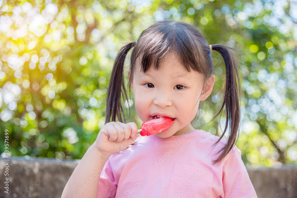 Little asian girl eating ice cream in park Little asian girl eating ice cream in park