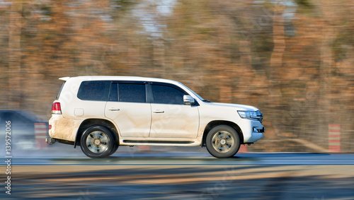 heavy SUV rides fast on the wet asphalt