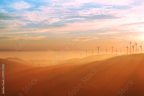 Wind turbines during sunset with Andalusian hills  Atlantic ocean and mountain of Africa on background.