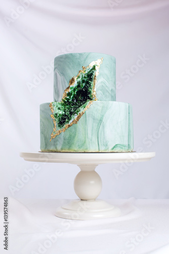 Wedding cake decorated like stone marble with emeralds in cut