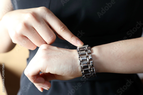 woman watching and pointing to the wrist watch