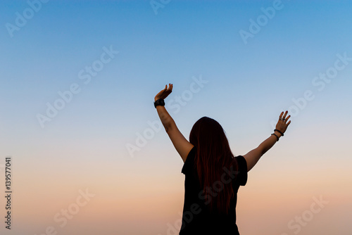 woman breathing fresh air with raised arms with