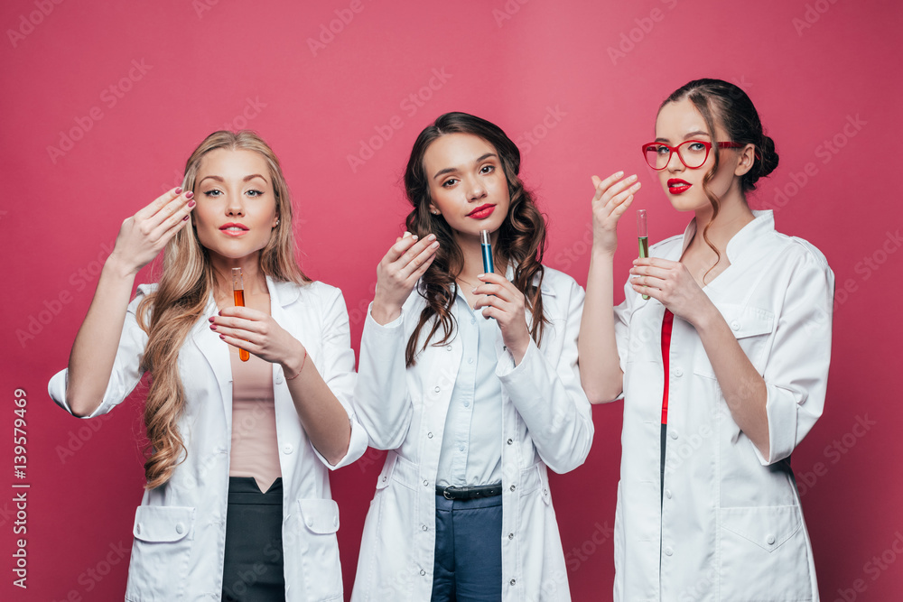 portrait of professional doctors smelling test tubes on pink portrait of professional doctors smelling test tubes on pink