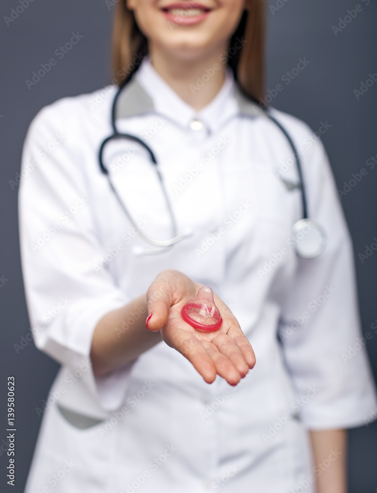 Doctor nurse offers safe sex Red condom on palm Conceptual  