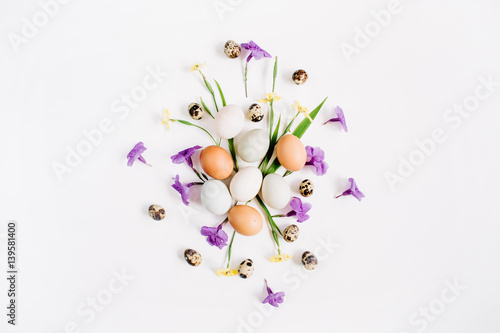 Easter eggs  quail eggs  yellow and purple flowers on white background. Flat lay  top view. Traditional spring concept. Easter concept.