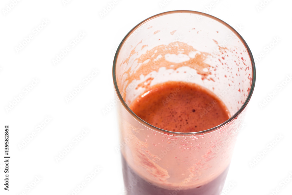 A glass of half full red healthy juice isolated over a white background A glass of half full red healthy juice isolated over a white background