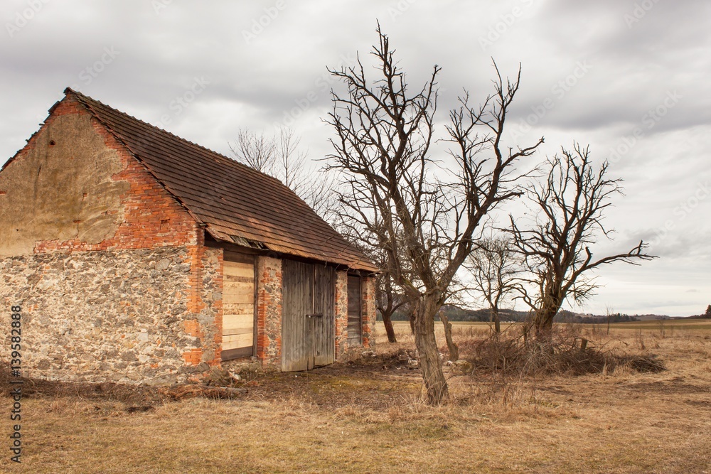 The old barn in the countryside. Farm buildings. Overcast sky above the farm. The old barn in the countryside. Farm buildings. Overcast sky above the farm.
