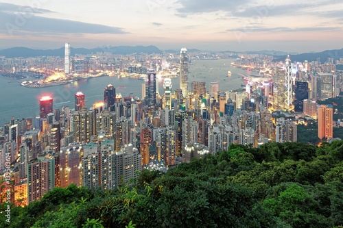 Night scenery of Hong Kong viewed from Victoria Peak with city skyline of crowded skyscrapers along Victoria Harbour and Kowloon area across seaport ~ Beautiful cityscape of Hong Kong at sunset