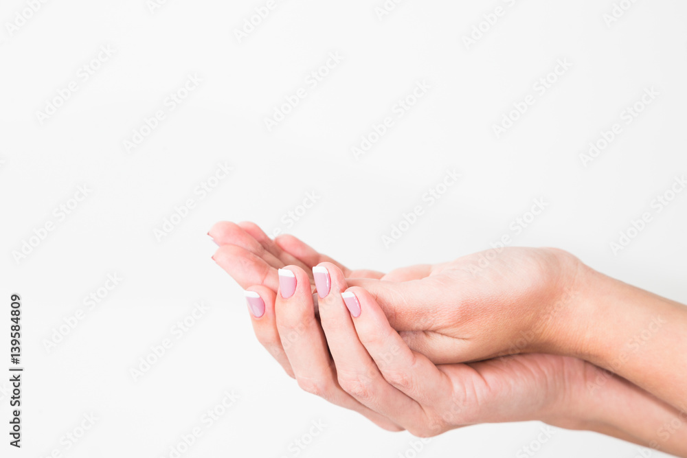 Close up of two female caucasian hands isolated on white background. Anonymous young woman holds hands as if showing something virtual and invisible on palms. Horizontal color image.