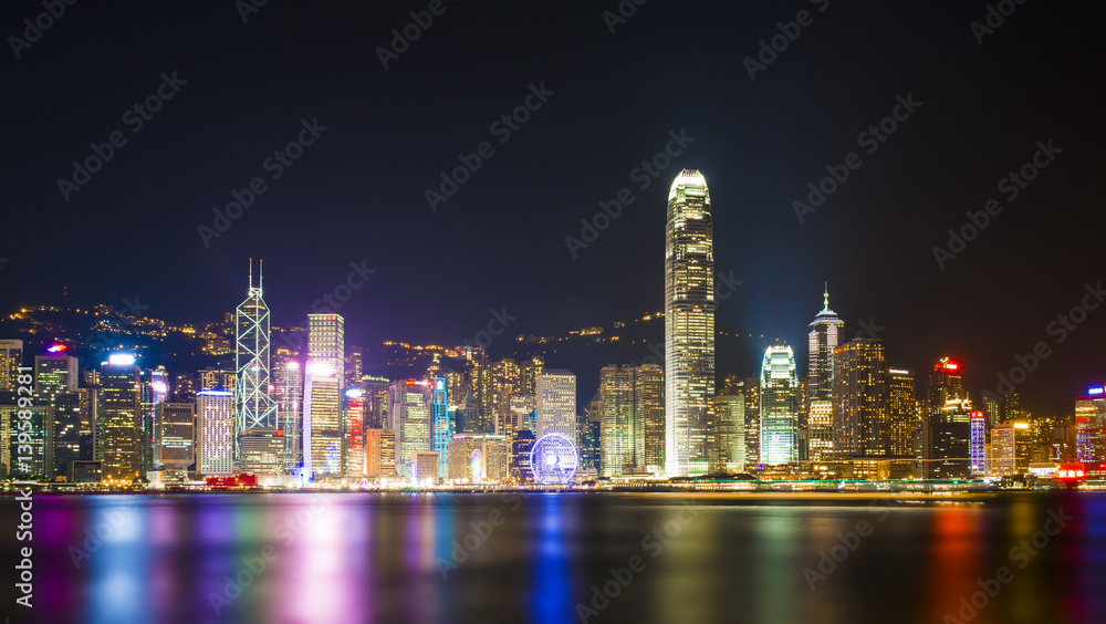 Stunning view of Hong Kong skyline and Victoria harbour seen from Harbour City from where is possible to attend the Symphony of Light, smooth water flowing in the foreground, Hong Kong.