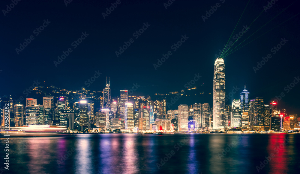 Stunning view of Hong Kong skyline and Victoria harbour seen from Harbour City from where is possible to attend the Symphony of Light, smooth water flowing in the foreground, Hong Kong. Stunning view of Hong Kong skyline and Victoria harbour seen from Harbour City from where is possible to attend the Symphony of Light, smooth water flowing in the foreground, Hong Kong.