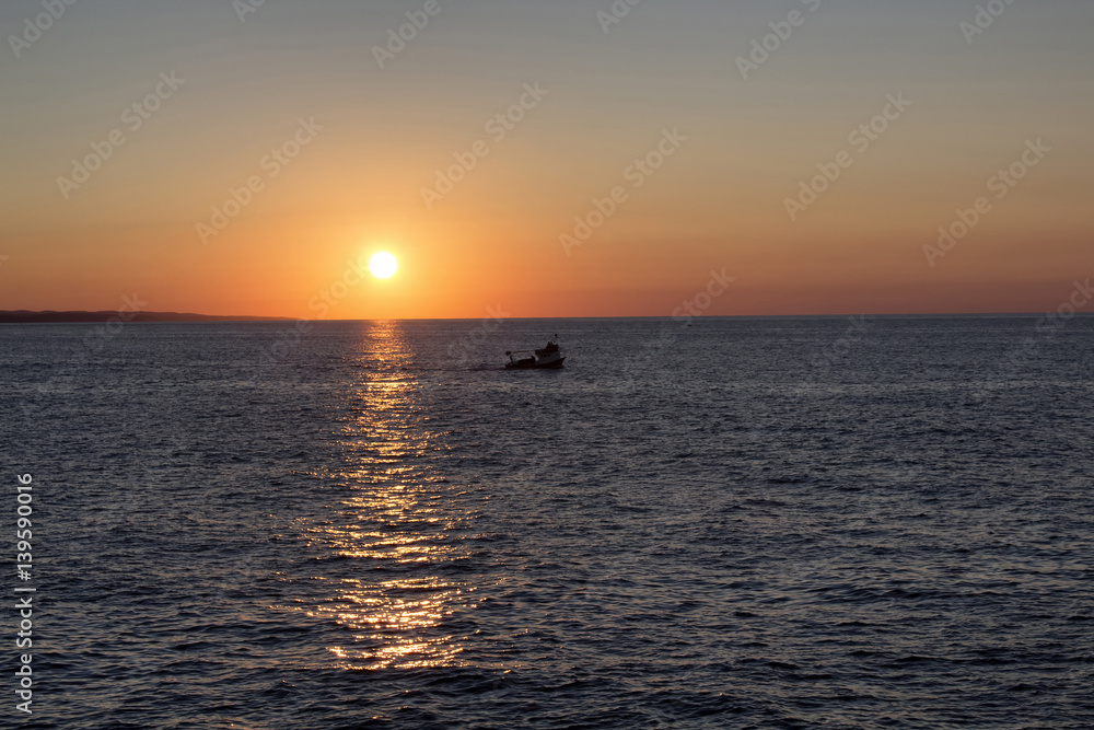 Fishing boat passing in sunset in Kerpe / Turkey