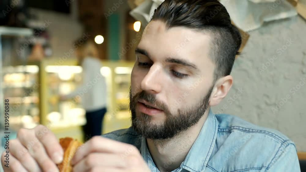 Handsome man with stylish hairstyle looks worried while eating croissant
Handsome man with stylish hairstyle looks worried while eating croissant
