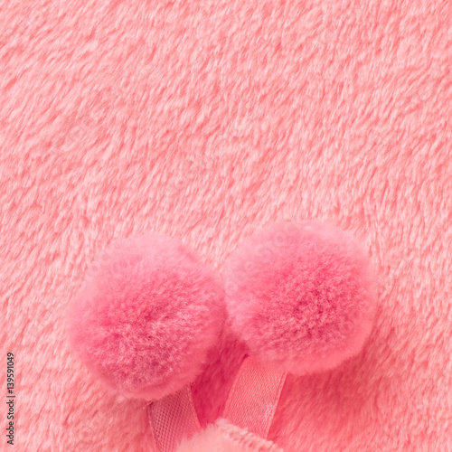 tender pink texture of towel like background with pompons, close up