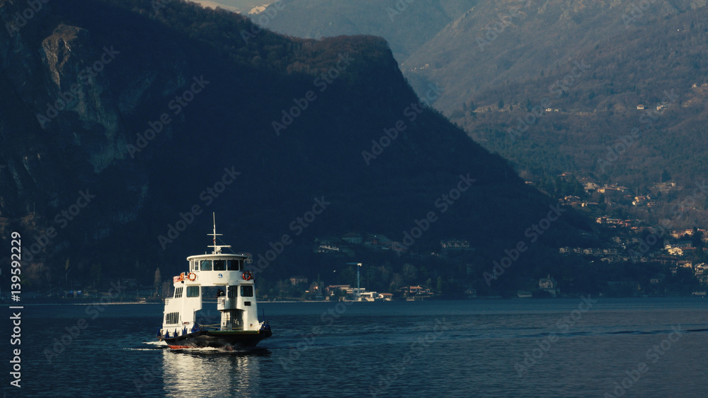 Mountains in the background ferry with passengers, Lake Como, Italy.