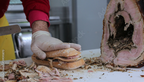slicing the meat of pork to prepare a sandwich in the food stall