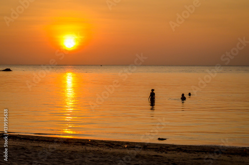 sunset at tropical beach with silhouettes