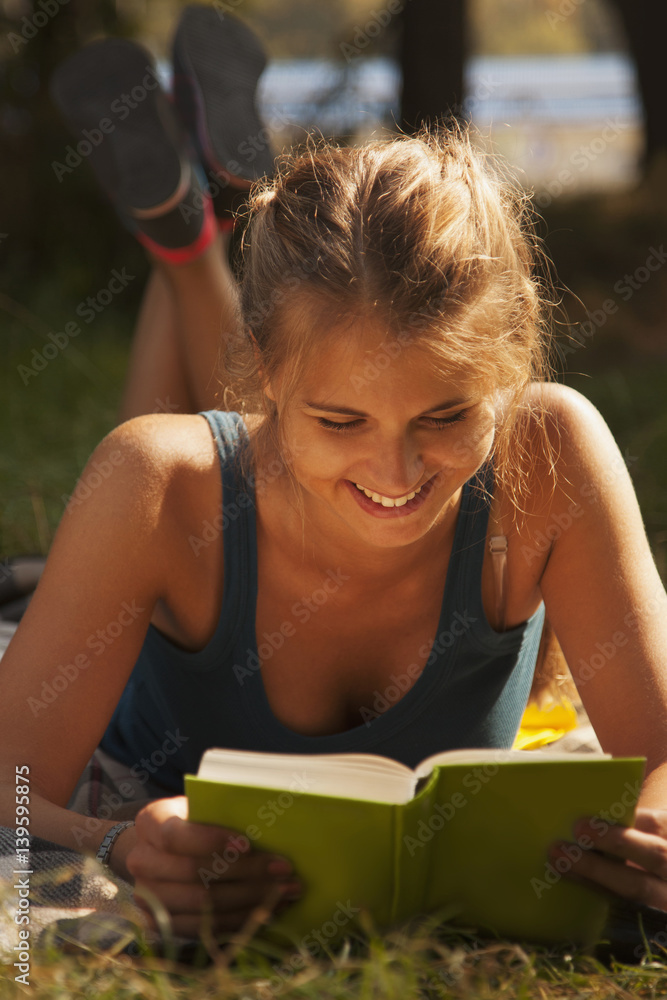 Happy young girl student learning on the grass in the park (education, self-development, self-organization, time management) Happy young girl student learning on the grass in the park (education, self-development, self-organization, time management)