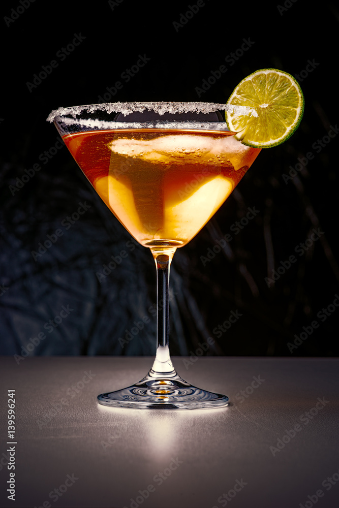 Cocktail in martini glass with sugar edges and slice of lime Cocktail in martini glass with sugar edges and slice of lime