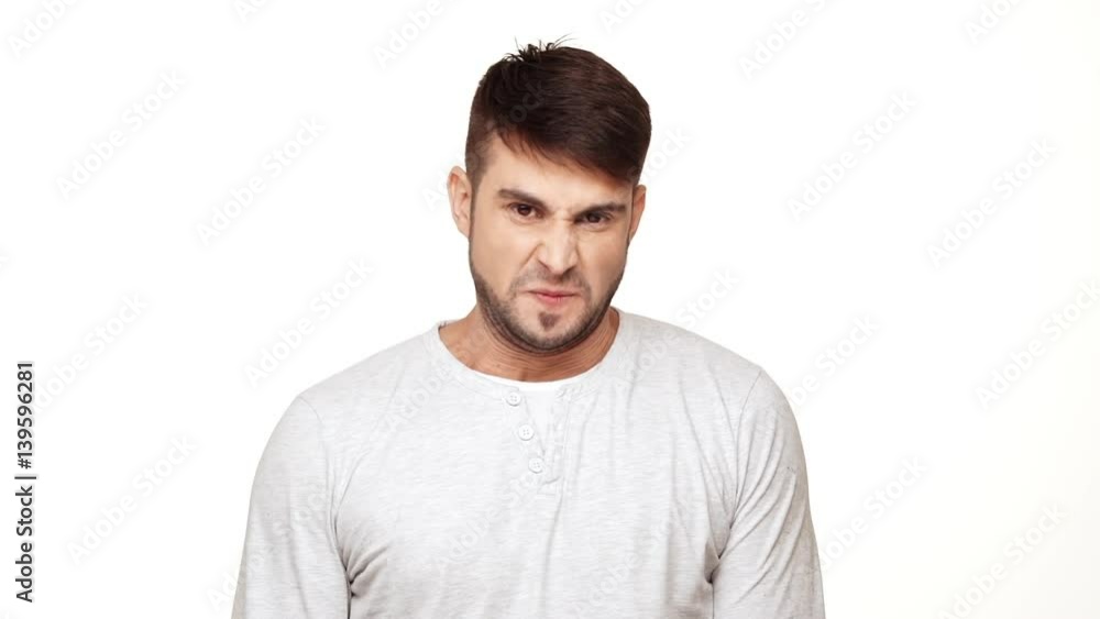 Tough Caucasian male in sweatshirt standing on white background awaiting punishment in slowmotion Tough Caucasian male in sweatshirt standing on white background awaiting punishment in slowmotion