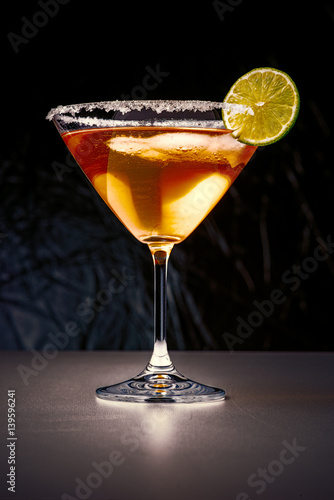 Cocktail in martini glass with sugar edges and slice of lime