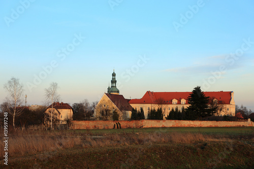 Kościół, zamek, klasztor w Czarnowąsach, jesienią.