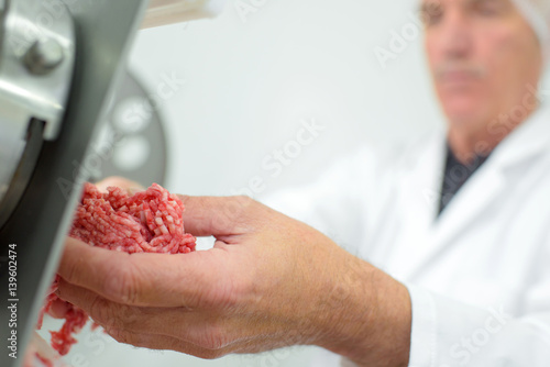 Closeup of butcher mincing meat