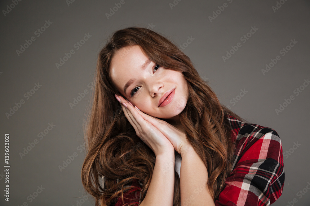 Fototapeta premium Lovely woman in plaid shirt standing and showing sleeping gesture