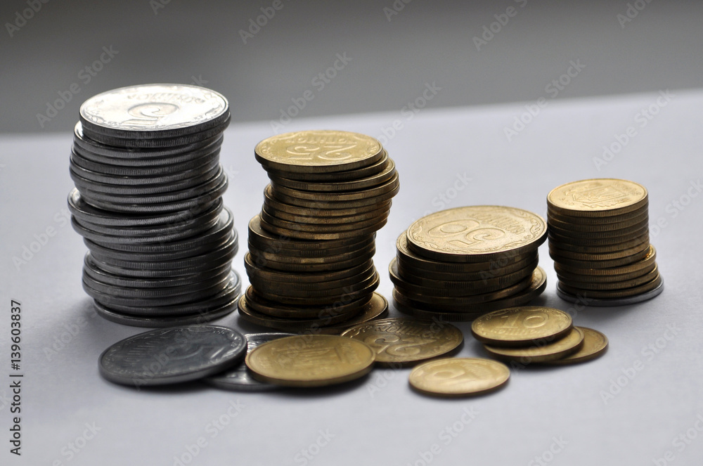 On the Ukrainian piles are metallic silver coins and yellow on a light background On the Ukrainian piles are metallic silver coins and yellow on a light background