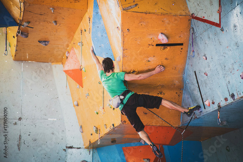 man climbs a route in a training room, competition