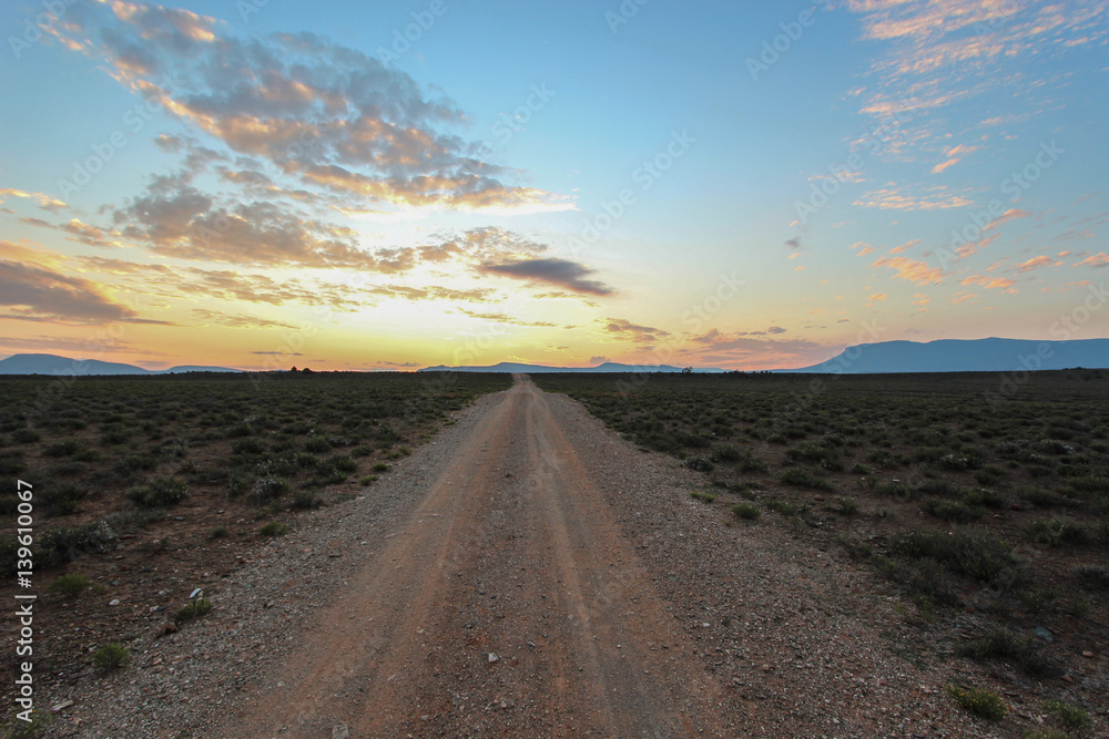 Long straight dirt road at sunset in Camdeboo National Park – South Africa