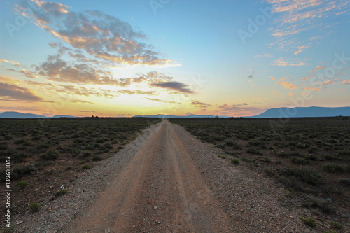 Long straight dirt road at sunset in Camdeboo National Park     South Africa