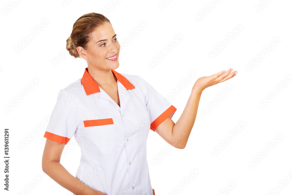 Smiling female doctor or nurse pointing at something Smiling female doctor or nurse pointing at something