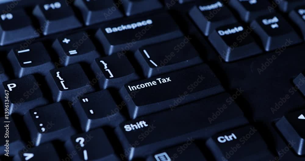 Human finger pressing an income tax button on the computer keyboard Human finger pressing an income tax button on the computer keyboard