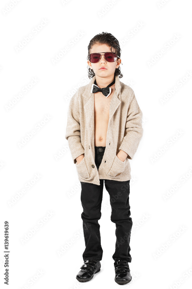 A curly-haired boy in sunglasses stands and looks into the camera. White background. A curly-haired boy in sunglasses stands and looks into the camera. White background.