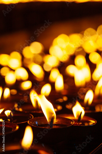 Many candle flames glowing in the dark