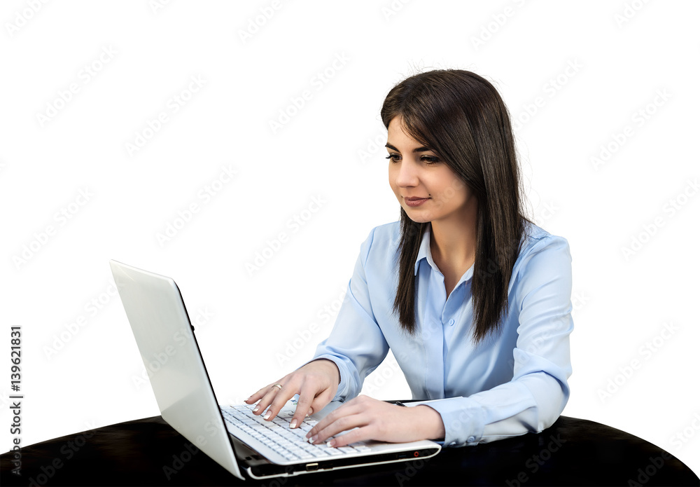 Young girl sitting in the office in front of computer, she is typing on a keyboard. White isolated background. Young girl sitting in the office in front of computer, she is typing on a keyboard. White isolated background.