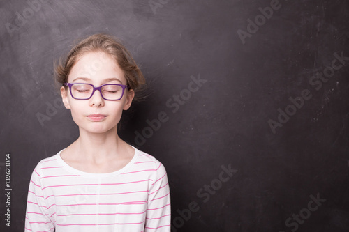 School - child girl with eyes closed at the blackboard