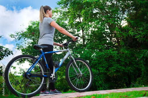 Beauty Young Blonde Woman Walking In Nature With Bicycle